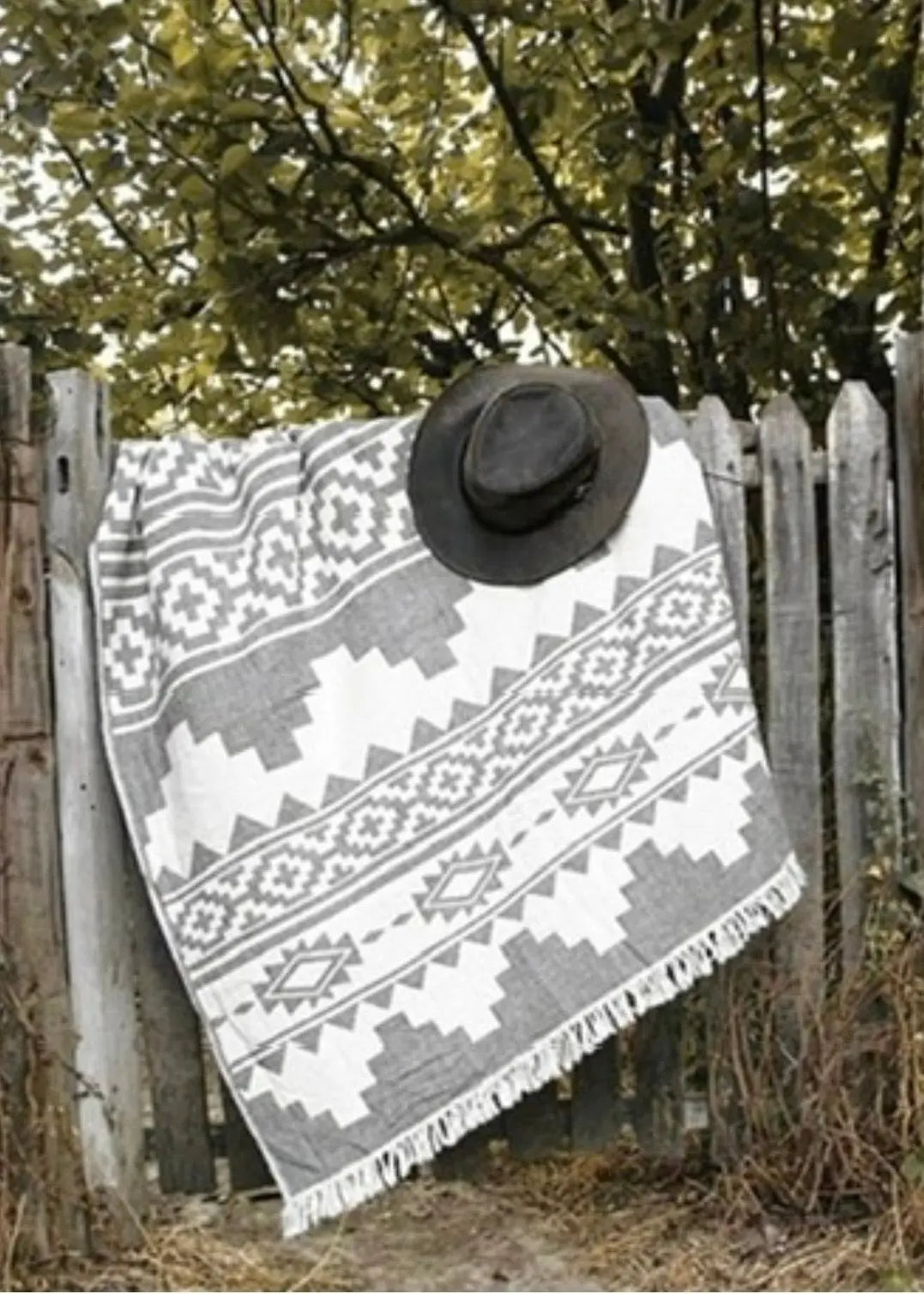 Rug Pestemal Turkish Towel, black and white patterned towel draped over a wooden fence with a black hat on top.